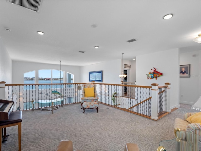 11000 8th St E, Treasure Island, FL 33706 - living area featuring carpet, recessed lighting, a water view, a chandelier, and an upstairs landing