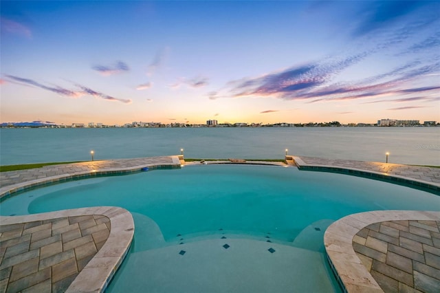 11000 8th St E, Treasure Island, FL 33706 - pool at dusk featuring a water view and an outdoor pool