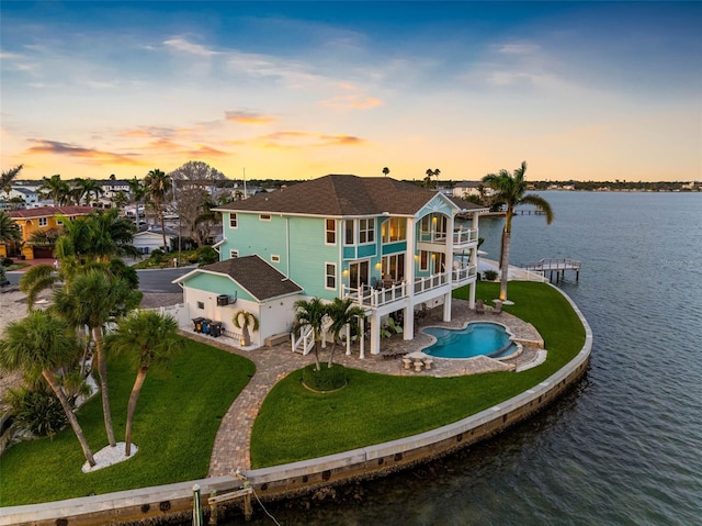 11000 8th St E, Treasure Island, FL 33706 - rear view of property featuring a balcony, a patio, a water view, a yard, and an outdoor pool