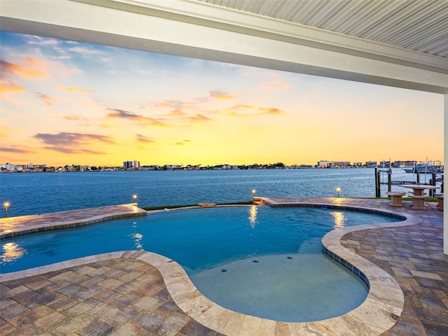 11000 8th St E, Treasure Island, FL 33706 - pool at dusk featuring an outdoor pool, a water view, and a dock