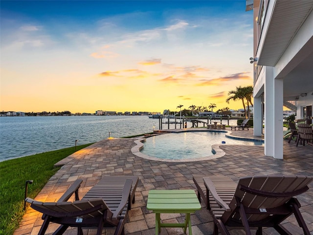 11000 8th St E, Treasure Island, FL 33706 - pool at dusk with a patio area, an outdoor pool, a water view, a boat dock, and boat lift