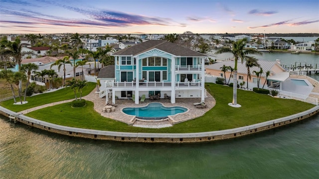 11000 8th St E, Treasure Island, FL 33706 - rear view of house with a balcony, a water view, a patio, an outdoor pool, and stairway