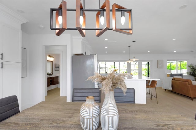 6508 Senegal Palm Way, Apollo Beach, FL 33572 - kitchen with open floor plan, white cabinets, a kitchen breakfast bar, light wood-type flooring, and recessed lighting