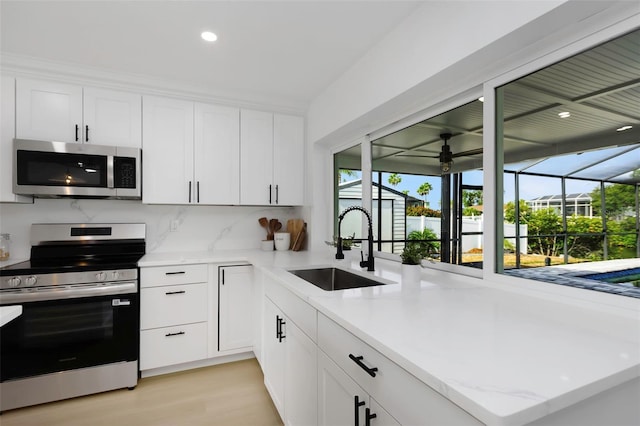 6508 Senegal Palm Way, Apollo Beach, FL 33572 - kitchen with stainless steel appliances, a sink, ceiling fan, white cabinets, and recessed lighting