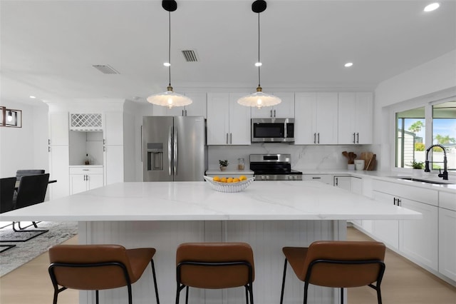 6508 Senegal Palm Way, Apollo Beach, FL 33572 - kitchen with appliances with stainless steel finishes, a sink, white cabinets, tasteful backsplash, and recessed lighting