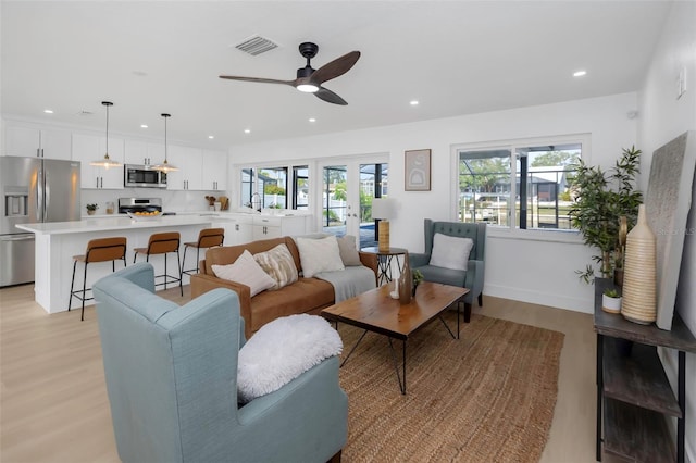 6508 Senegal Palm Way, Apollo Beach, FL 33572 - living room with light wood finished floors, recessed lighting, ceiling fan, and french doors