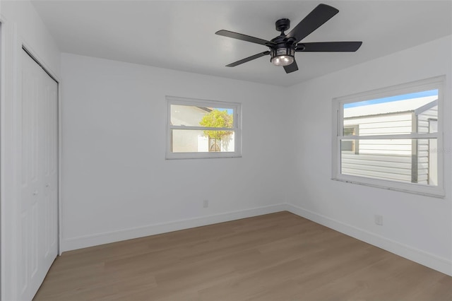 6508 Senegal Palm Way, Apollo Beach, FL 33572 - unfurnished bedroom featuring light wood finished floors, multiple windows, baseboards, and a closet