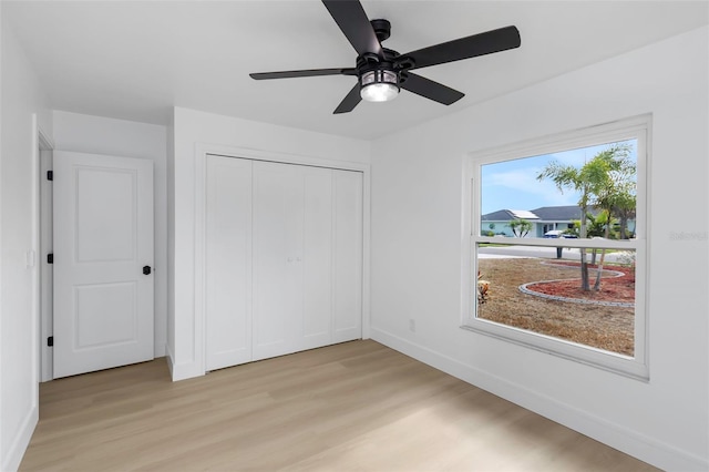 6508 Senegal Palm Way, Apollo Beach, FL 33572 - unfurnished bedroom with light wood-style floors, baseboards, a closet, and a ceiling fan