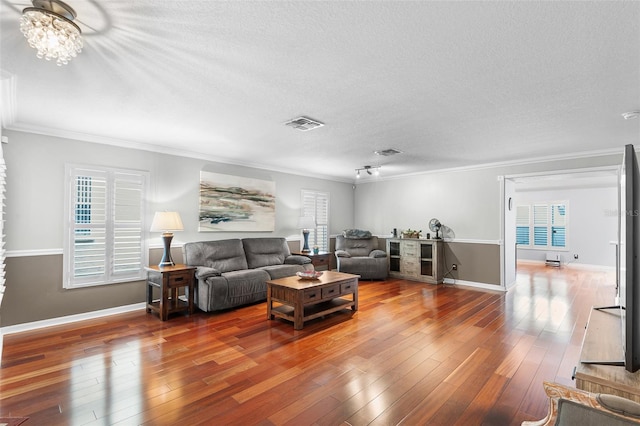 3351 Lintower Dr, Land O Lakes, FL 34638 - living area featuring a textured ceiling, wood-type flooring, ornamental molding, baseboards, and a chandelier