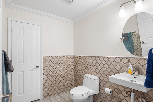 3351 Lintower Dr, Land O Lakes, FL 34638 - bathroom with toilet, crown molding, wainscoting, and tile walls