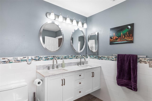 3351 Lintower Dr, Land O Lakes, FL 34638 - full bathroom with tile walls, double vanity, toilet, and wainscoting