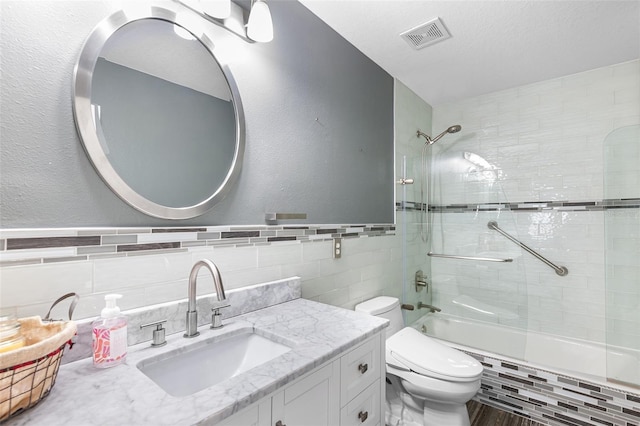 3351 Lintower Dr, Land O Lakes, FL 34638 - bathroom with tile walls, tiled shower / bath, toilet, vanity, and a textured wall