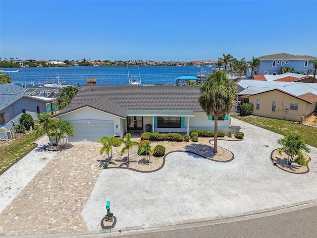6322 Cocoa Ln, Apollo Beach, FL 33572 - ranch-style house with an attached garage, driveway, french doors, a water view, and stucco siding