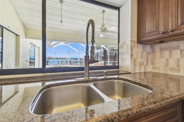 6322 Cocoa Ln, Apollo Beach, FL 33572 - kitchen view of a sink, dark stone countertops, a sunroom, and decorative backsplash