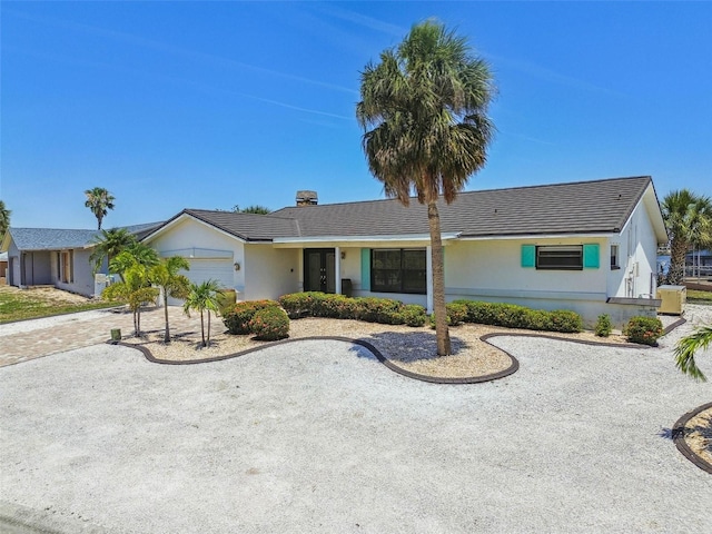 6322 Cocoa Ln, Apollo Beach, FL 33572 - ranch-style home with an attached garage, stucco siding, driveway, and a chimney
