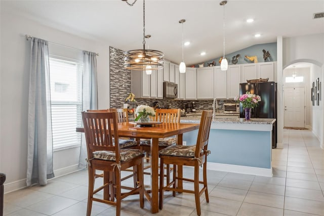 6555 Sparkling Way, Wesley Chapel, FL 33545 - dining area featuring arched walkways, lofted ceiling, light tile patterned floors, recessed lighting, and baseboards