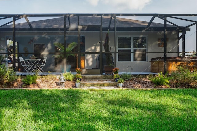 6555 Sparkling Way, Wesley Chapel, FL 33545 - rear view of house with glass enclosure, a lawn, and stucco siding