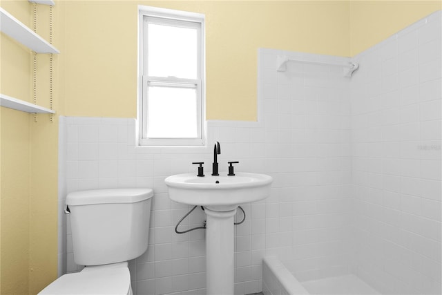 9780 Allen Rd, Lithia, FL 33547 - bathroom featuring tile walls, healthy amount of natural light, toilet, a wainscoted wall, and a shower