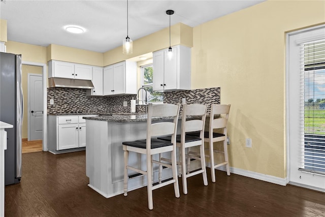 9780 Allen Rd, Lithia, FL 33547 - kitchen with freestanding refrigerator, backsplash, under cabinet range hood, and a peninsula