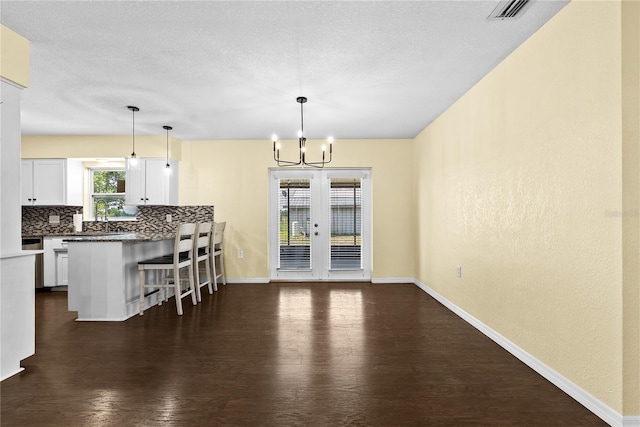9780 Allen Rd, Lithia, FL 33547 - kitchen featuring a kitchen bar, dark wood finished floors, white cabinetry, and a chandelier