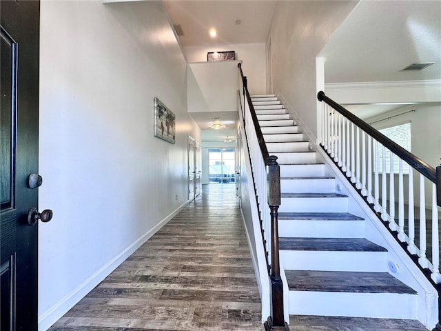 stairway with wood finished floors and baseboards