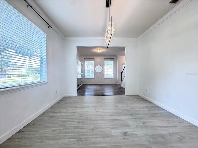 unfurnished dining area with wood finished floors, baseboards, and ornamental molding