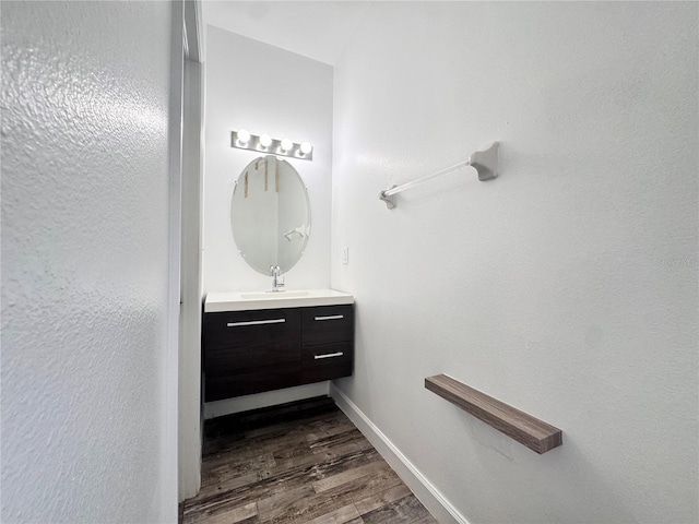 bathroom featuring wood finished floors, vanity, and baseboards