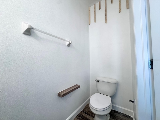 bathroom featuring wood finished floors, baseboards, and toilet