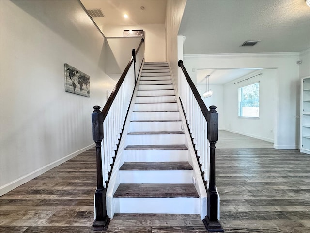 stairs with ornamental molding, baseboards, and wood finished floors