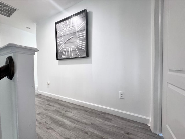 corridor featuring wood finished floors and baseboards