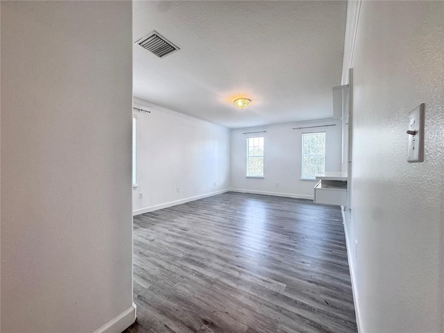 spare room featuring baseboards and dark wood-type flooring