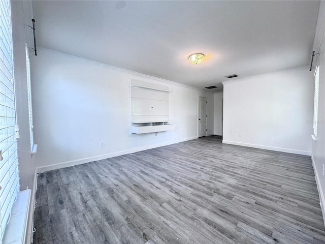 unfurnished living room with wood finished floors and baseboards