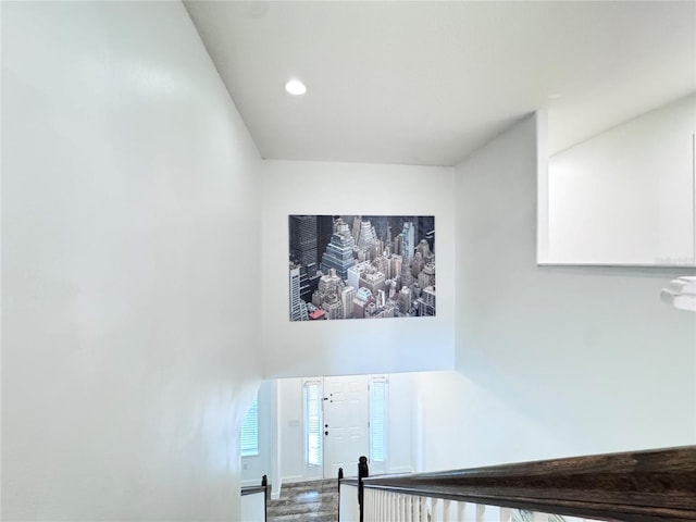 stairs with wood finished floors and recessed lighting