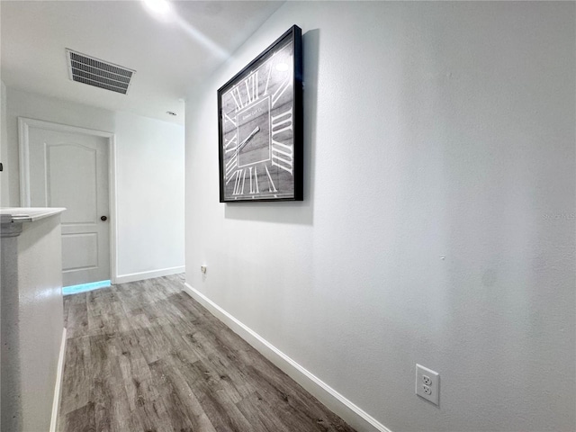 hallway featuring baseboards and wood finished floors