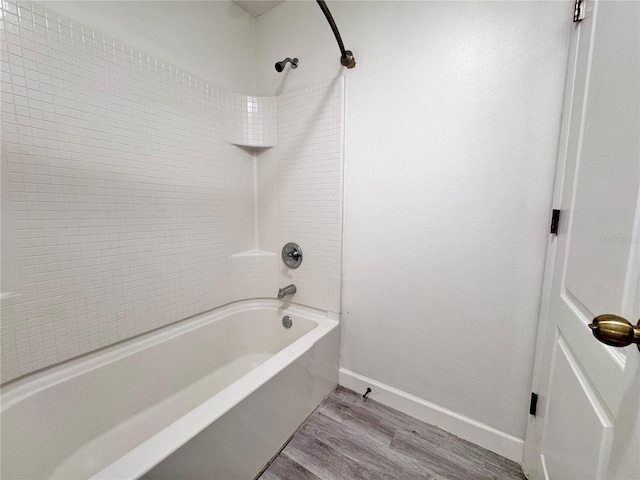 bathroom featuring wood finished floors, baseboards, and shower / bathtub combination