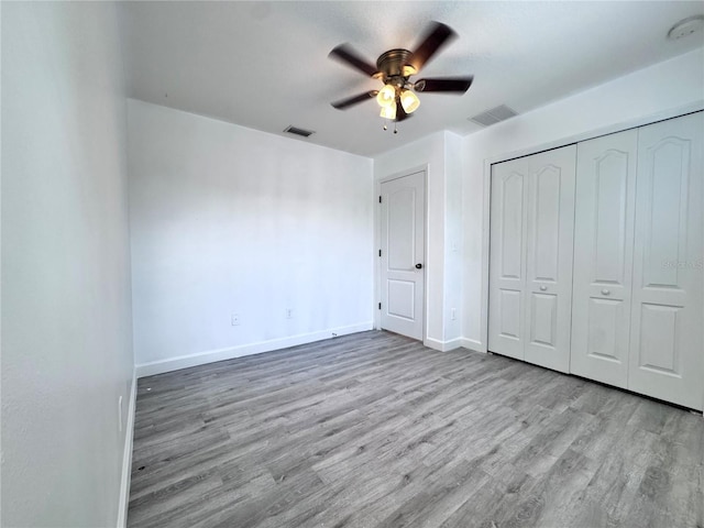 unfurnished bedroom with wood finished floors, baseboards, a closet, and ceiling fan