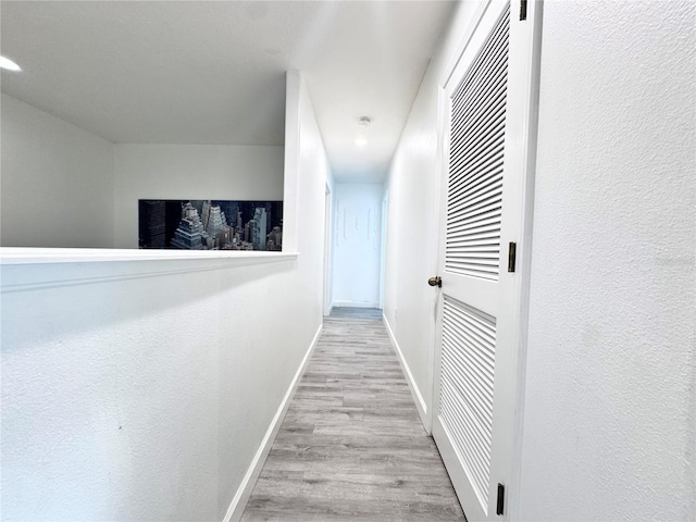 hall with a heating unit, baseboards, wood finished floors, and recessed lighting