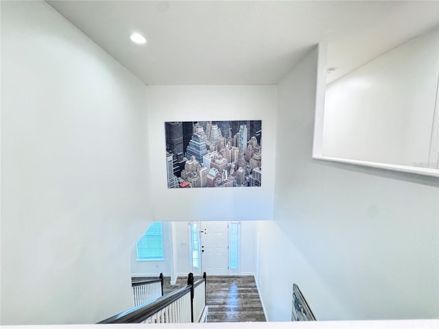 staircase with wood finished floors and recessed lighting