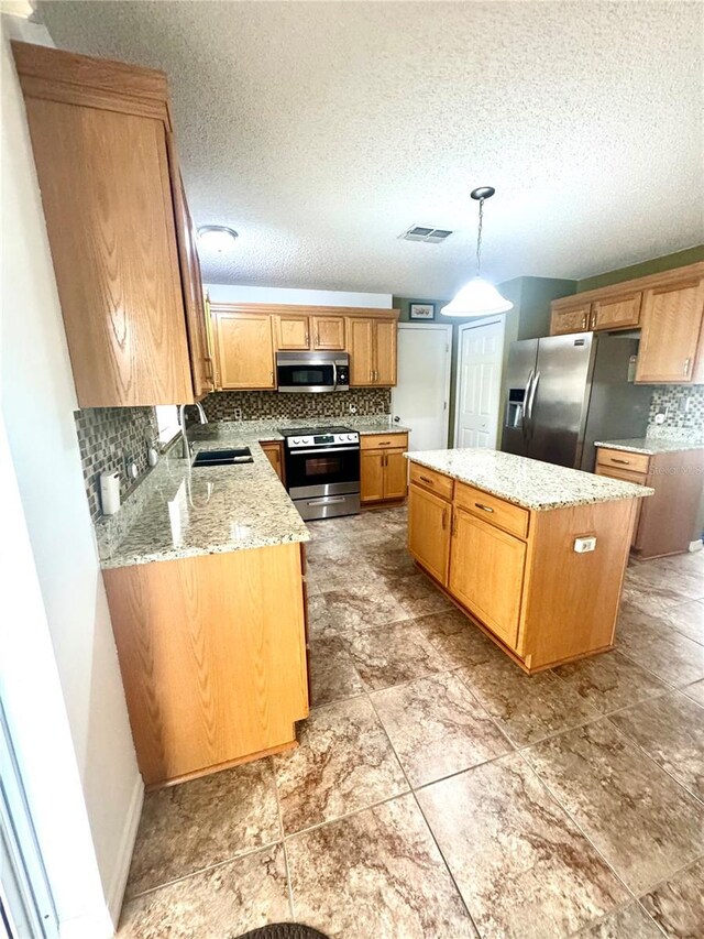 3181 Deltona Blvd, Spring Hill, FL 34606 - kitchen with appliances with stainless steel finishes, a sink, backsplash, a kitchen island, and a textured ceiling
