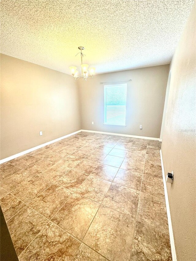 3181 Deltona Blvd, Spring Hill, FL 34606 - unfurnished room with a chandelier, a textured ceiling, baseboards, and tile patterned flooring
