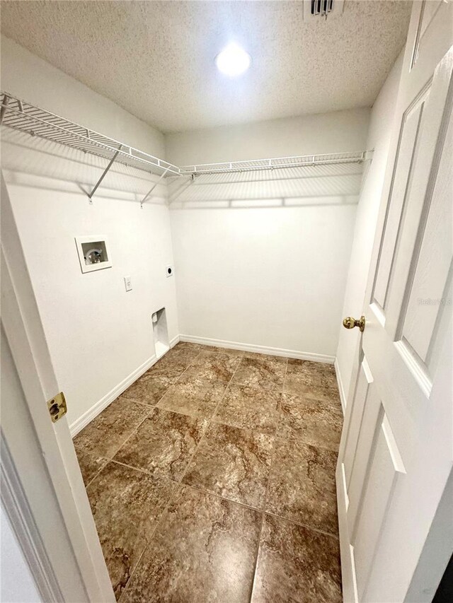 3181 Deltona Blvd, Spring Hill, FL 34606 - laundry room featuring hookup for an electric dryer, washer hookup, a textured ceiling, and baseboards