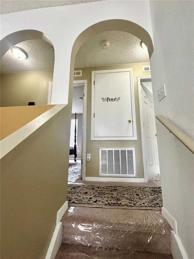3181 Deltona Blvd, Spring Hill, FL 34606 - staircase with a textured ceiling, arched walkways, and baseboards