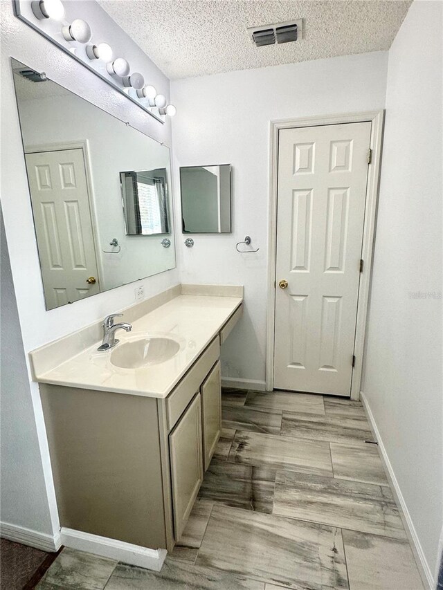 3181 Deltona Blvd, Spring Hill, FL 34606 - bathroom featuring vanity, a textured ceiling, and baseboards