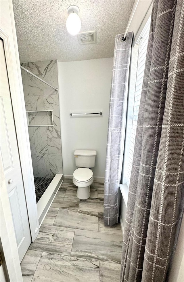 3181 Deltona Blvd, Spring Hill, FL 34606 - bathroom with toilet, a textured ceiling, shower / bath combo, and wood finished floors