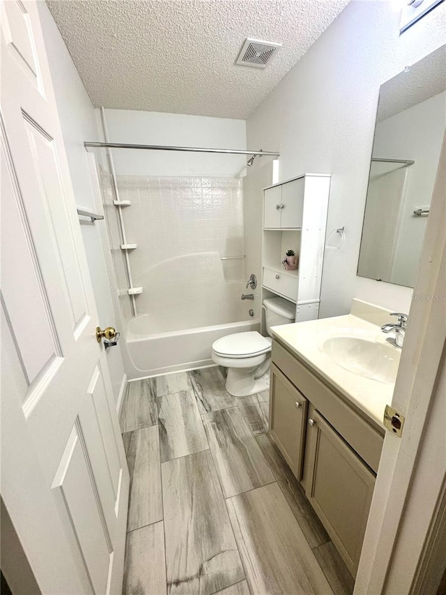 3181 Deltona Blvd, Spring Hill, FL 34606 - bathroom featuring bathtub / shower combination, vanity, a textured ceiling, toilet, and wood finished floors