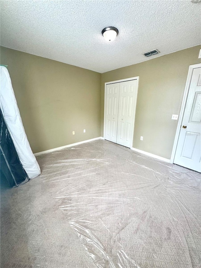 3181 Deltona Blvd, Spring Hill, FL 34606 - unfurnished bedroom with carpet flooring, a closet, baseboards, and a textured ceiling