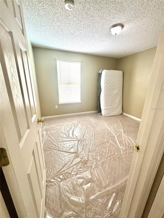 3181 Deltona Blvd, Spring Hill, FL 34606 - carpeted empty room with a textured ceiling and baseboards