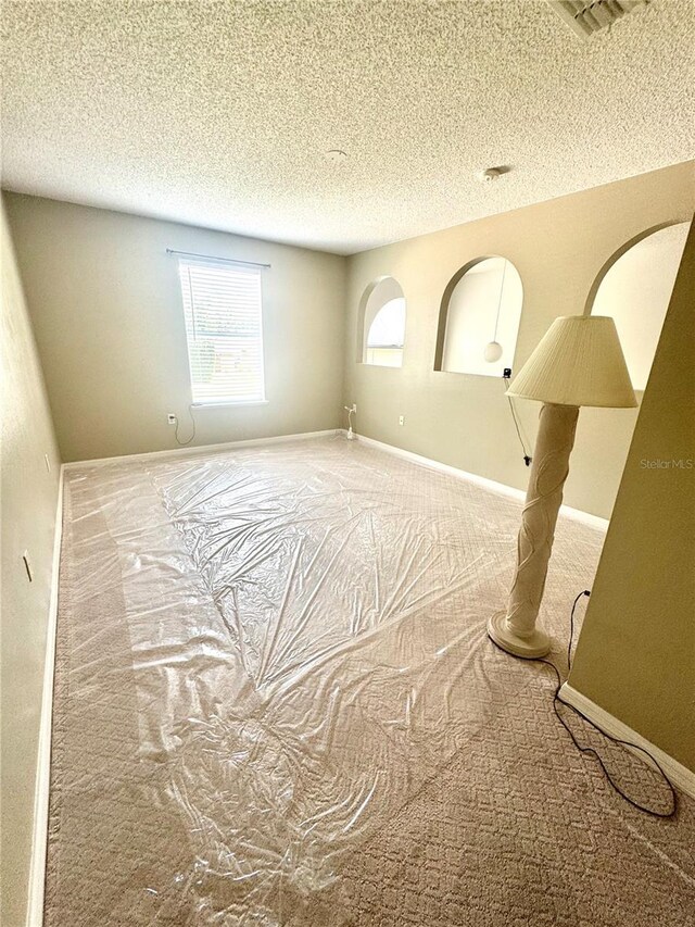 3181 Deltona Blvd, Spring Hill, FL 34606 - empty room with carpet floors, a textured ceiling, and baseboards