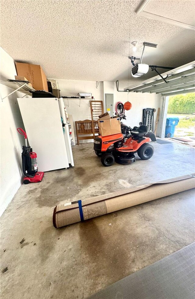 3181 Deltona Blvd, Spring Hill, FL 34606 - garage with electric panel, a garage door opener, and freestanding refrigerator
