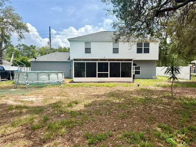 3181 Deltona Blvd, Spring Hill, FL 34606 - rear view of property featuring a sunroom, an outdoor pool, and a shingled roof